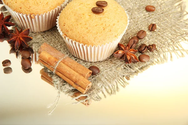 Savoureux muffins sur toile de jute, épices et graines de café, sur fond beige — Photo