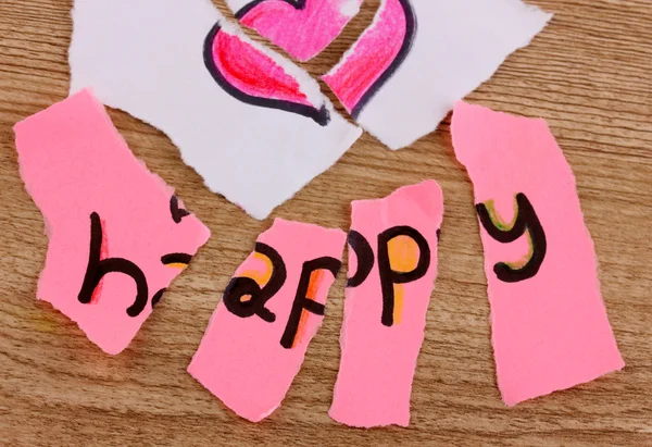 Zerrissenes Papier mit Worten in glücklicher Nahaufnahme auf Holztisch — Stockfoto