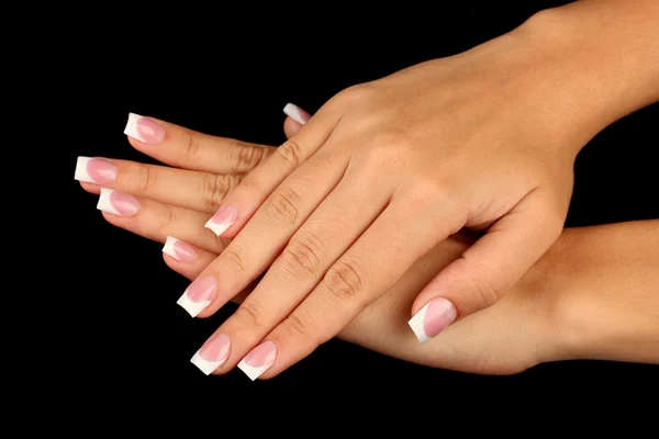 Beautiful woman's hands with french manicure on black background — Stock Photo, Image