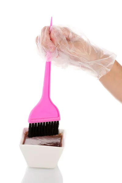 La mano della donna in un guanto immerge il pennello nella tintura per capelli, su sfondo bianco — Foto Stock