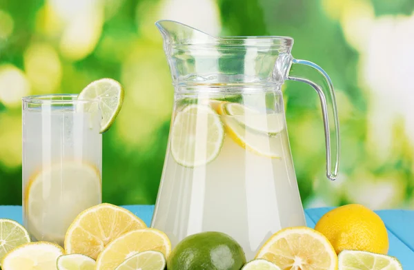 Citrice limonadă în ulcior și pahar de citrice în jur — Fotografie, imagine de stoc