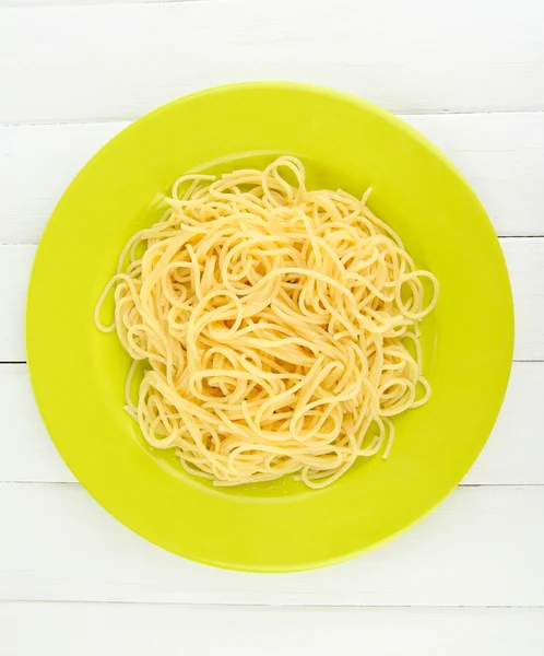Italian spaghetti in plate on wooden table — Stock Photo, Image