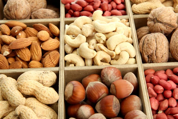 Assortment of tasty nuts in wooden box, close up — Stock Photo, Image