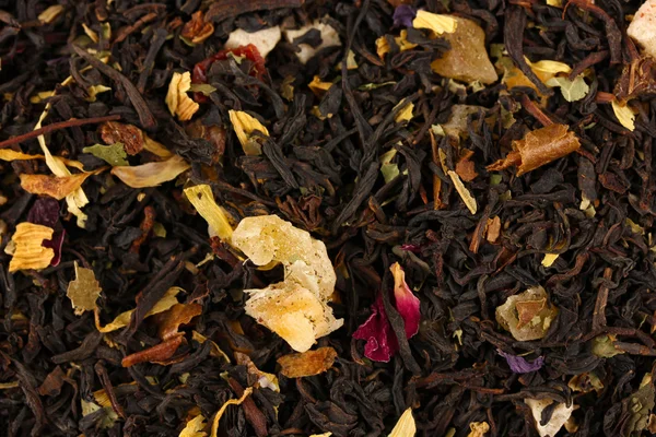 Aromatic black dry tea with fruits and petals, close up — Stock Photo, Image