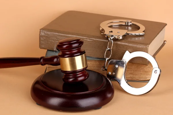 Gavel, handcuffs and book on law on beige background — Stock Photo, Image