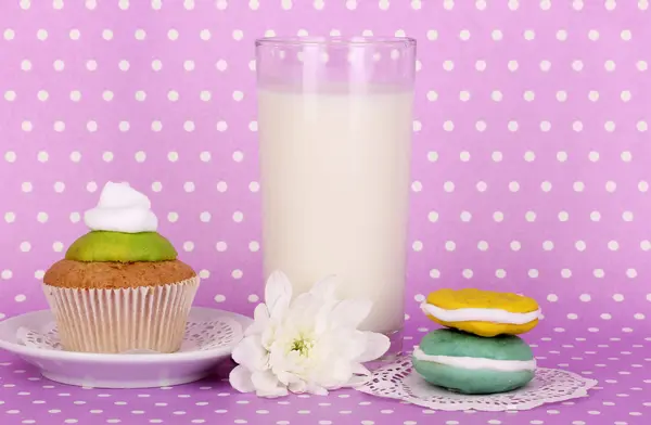 Glas färsk ny mjölk med Konfektyr på lila prickiga bakgrund — Stockfoto