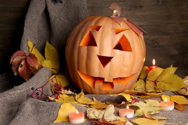 Halloween pompoen en herfst bladeren, op houten achtergrond — Stockfoto