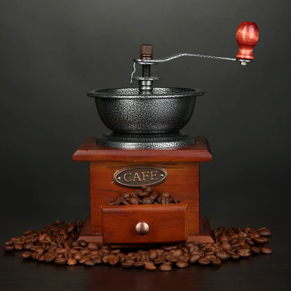 Coffee grinder with coffee beans on grey background — Stock Photo, Image