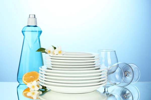 Empty clean plates and glasses with dishwashing liquid, sponges and lemon — Stock Photo, Image