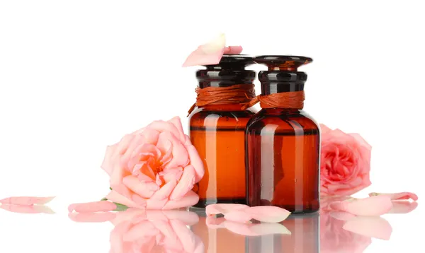 Garrafas de óleo e rosas isoladas sobre branco — Fotografia de Stock