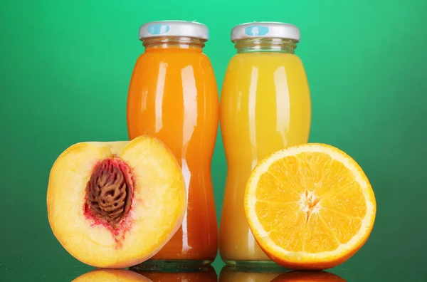 병 및 오렌지와 화려한 배경에 옆 복숭아 맛 있는 오렌지와 복숭아 주스 — 스톡 사진