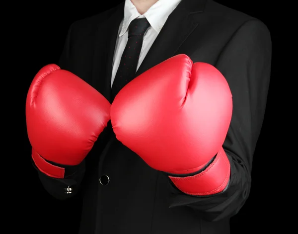 Businessman in boxing gloves isolated on black — Stock Photo, Image