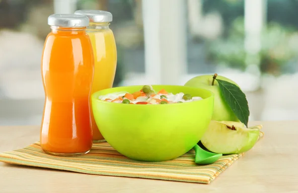 Tasty dieting food and bottles of juice, on wooden table — Stock Photo, Image