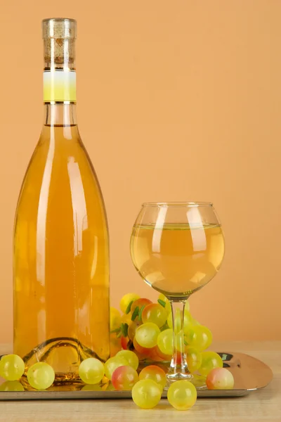 Weißwein im Glas mit Flasche auf Salver auf beigem Hintergrund — Stockfoto