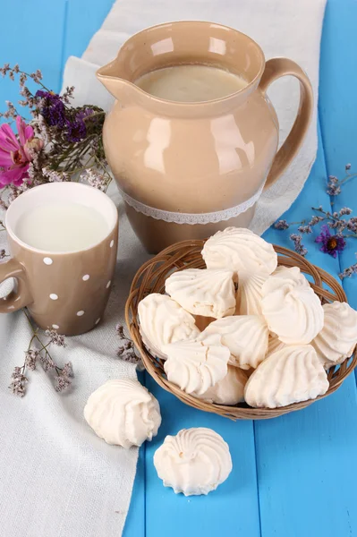 Pitcher and cup of milk with meringues on wooden table close-up — Stock Photo, Image
