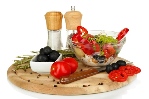 Salada grega fresca em taça de vidro cercada por ingredientes para cozinhar isolada em branco — Fotografia de Stock