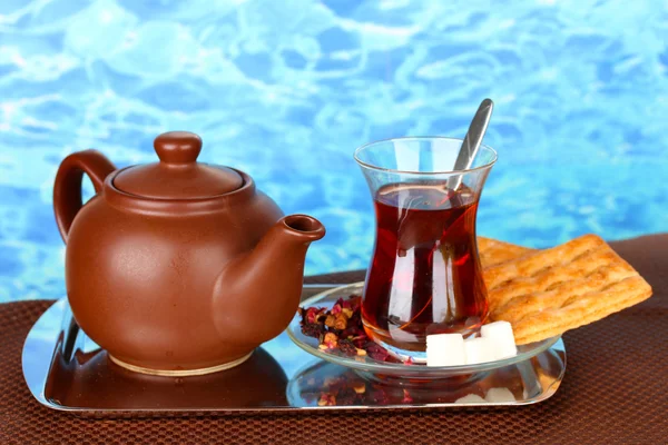 Glass of Turkish tea and kettle on color background — Stock Photo, Image