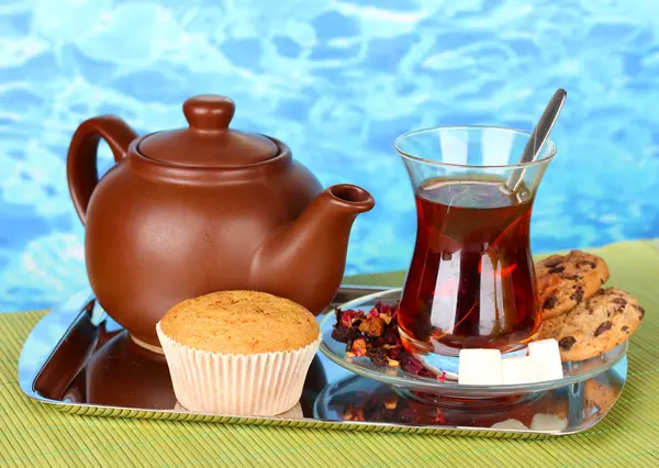 Glass of Turkish tea and kettle on color background — Stock Photo, Image