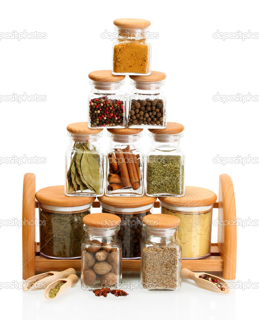 jars and wooden spoons with spices isolated on white