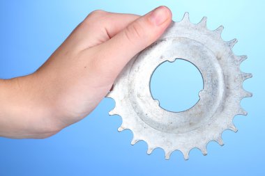 metal dişli mavi zemin üzerine elinde tutan adam