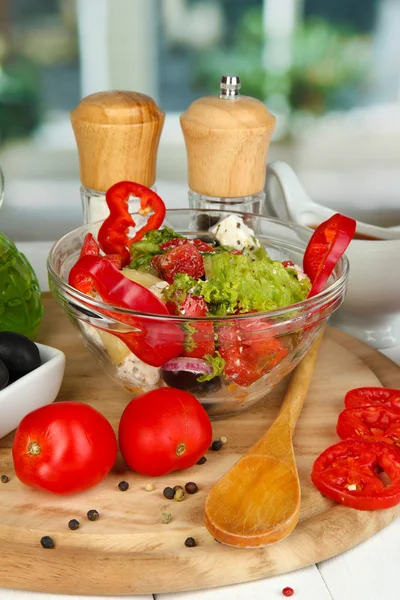 창 배경 클로즈업에 나무 테이블에 요리 재료에 의해 포위 하는 유리 그릇에 신선한 그리스 샐러드 — 스톡 사진