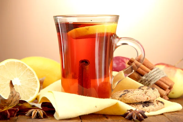 Φλιτζάνι ζεστό τσάι και φύλλα του φθινοπώρου, σε καφέ φόντο — Φωτογραφία Αρχείου