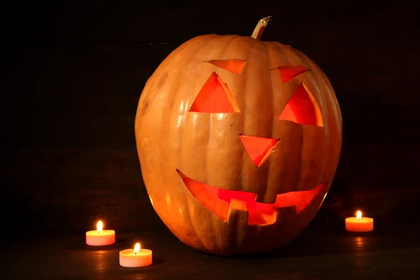 Halloween pumpa och ljus på trä bakgrund — Stockfoto