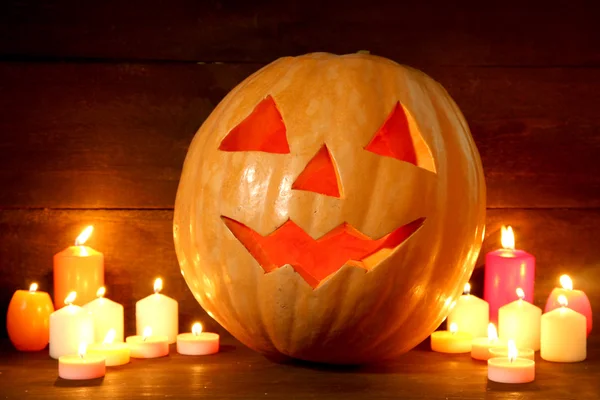 Calabaza y velas de halloween, sobre fondo de madera — Foto de Stock