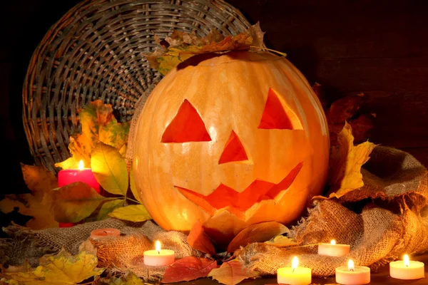 Halloween pumpkin and autumn leaves, on wooden background — Stock Photo, Image