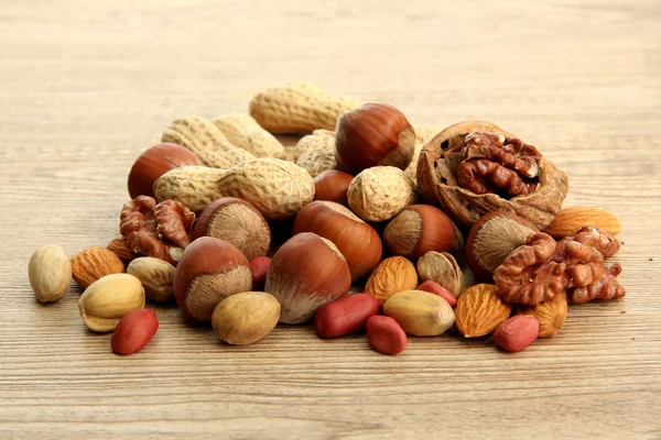 Assortiment van smakelijke noten op houten achtergrond — Stockfoto