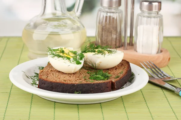 緑の背景に暗いパンにゆでた卵 — ストック写真