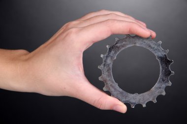 metal dişli gri arka plan üzerinde elinde tutan adam