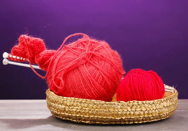 A kosár, fából készült tábla, lila háttér piros knittings fonal — Stock Fotó