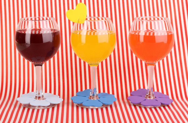 Πολύχρωμο κοκτέιλ με φωτεινή διακόσμηση για ποτήρια σε κόκκινο φόντο — Φωτογραφία Αρχείου