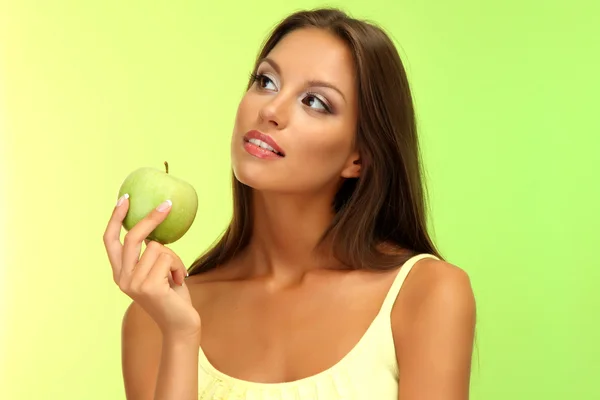 Hermosa joven con manzana verde, sobre fondo verde — Foto de Stock