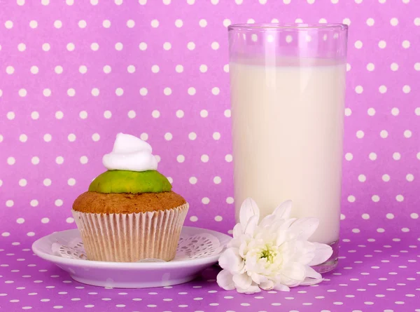 Glass of fresh new milk with cake on purple polka dot background — Stock Photo, Image