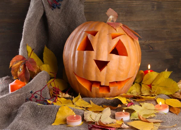 Calabaza de halloween y hojas de otoño, sobre fondo de madera — Foto de Stock