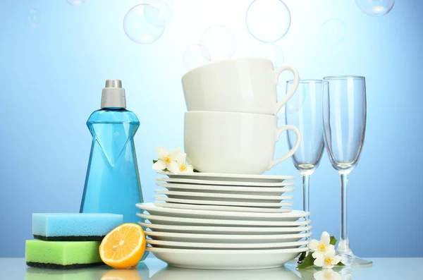 Пустые чистые тарелки, стаканы и чашки с жидкостью для мытья посуды — стоковое фото