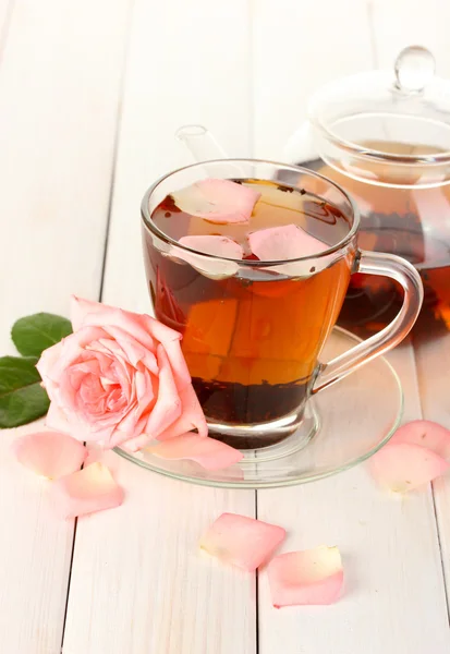 ティーポットと白の木製テーブルにバラでお茶のカップ — ストック写真