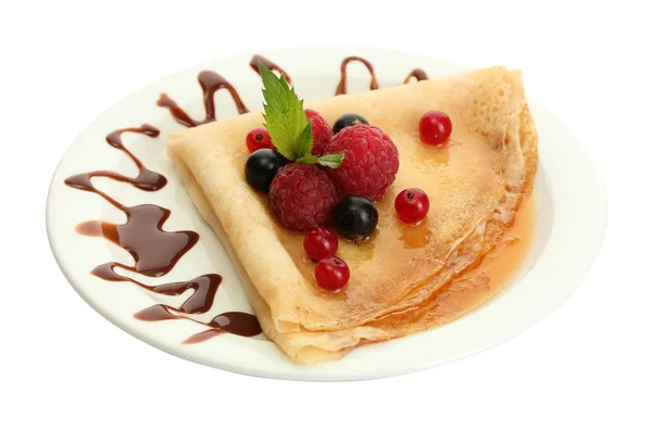 Вкусные блины с ягодами, шоколадом и медом на тарелке — стоковое фото