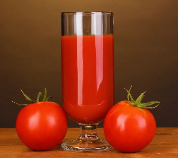 Sumo de tomate em vidro sobre mesa de madeira sobre fundo marrom — Fotografia de Stock