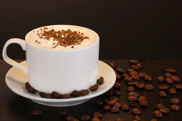 Latte na mesa de madeira no fundo marrom — Fotografia de Stock