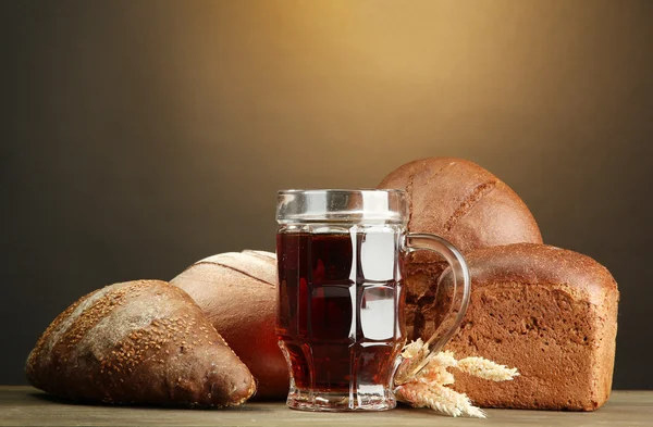 Tankard van kvas en rogge brood met oren, op houten tafel — Stockfoto