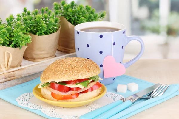 Appetizing sandwich on color plate on wooden table on window background — Stock Photo, Image