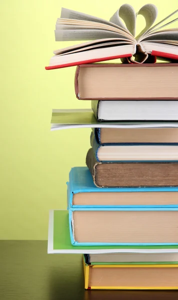 Empilement de livres et magazines intéressants sur table en bois sur fond vert — Photo