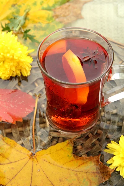 Cup of hot drink and autumn leaves, close up — Stock Photo, Image