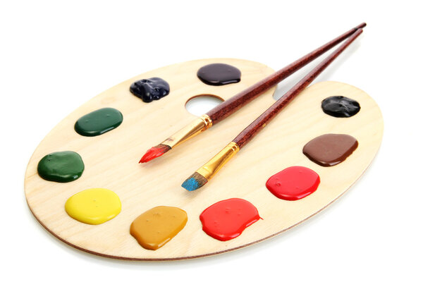 wooden art palette with paint and brushes isolated on white