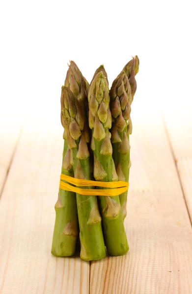 Asperges utiles sur table en bois sur fond blanc — Photo