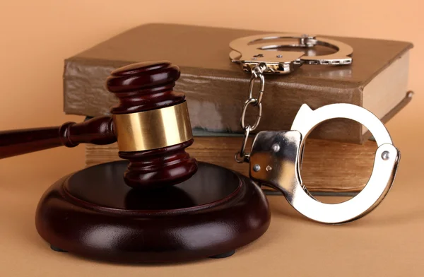 Gavel, handcuffs and book on law on beige background — Stock Photo, Image