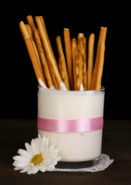 Tasty crispy sticks in glass with sour cream isolated on black — Stock Photo, Image